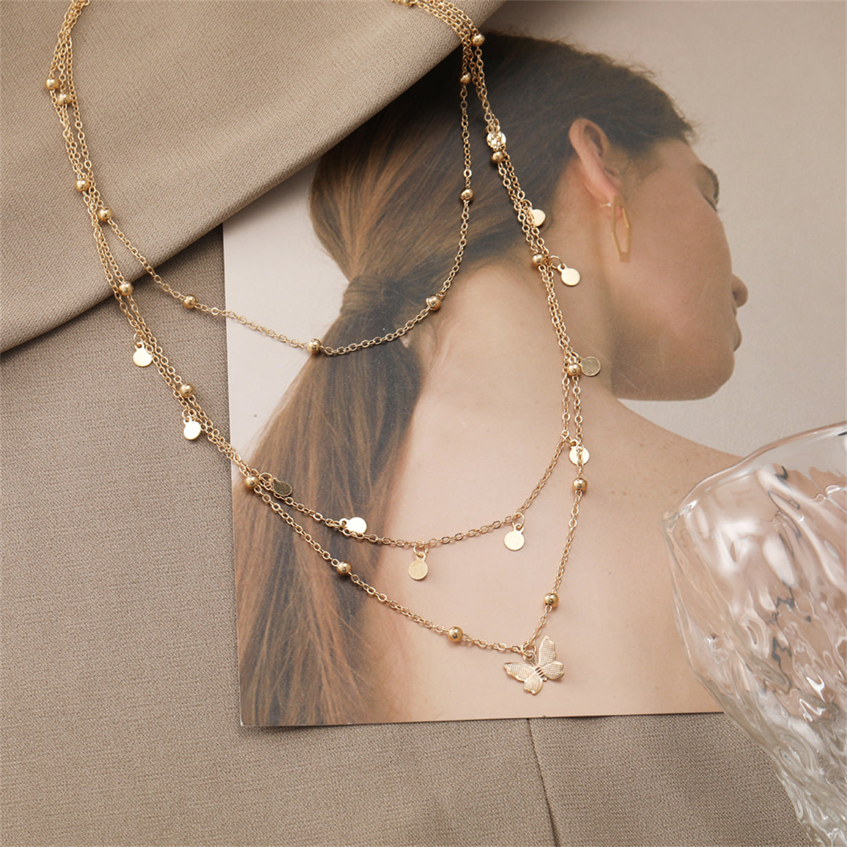Beautifully crafted 18K gold-plated butterfly necklace with three layers of gold beads, adding elegance to your style.