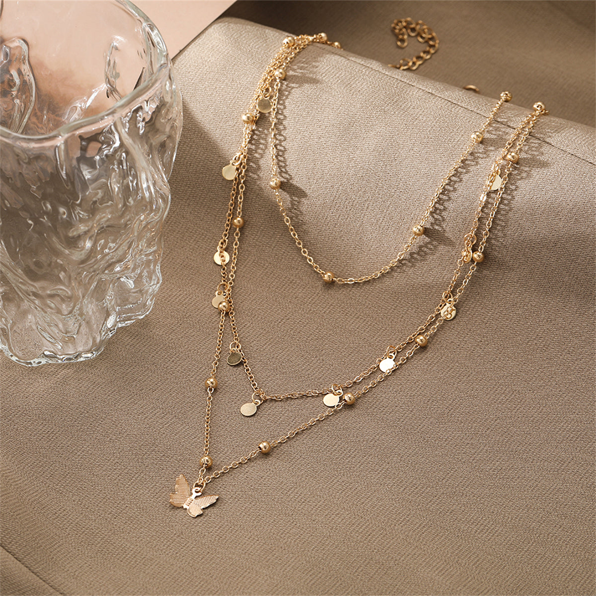 Stunning 18K gold-plated butterfly layered necklace with three exquisite layers of gold beads for a chic accessory.