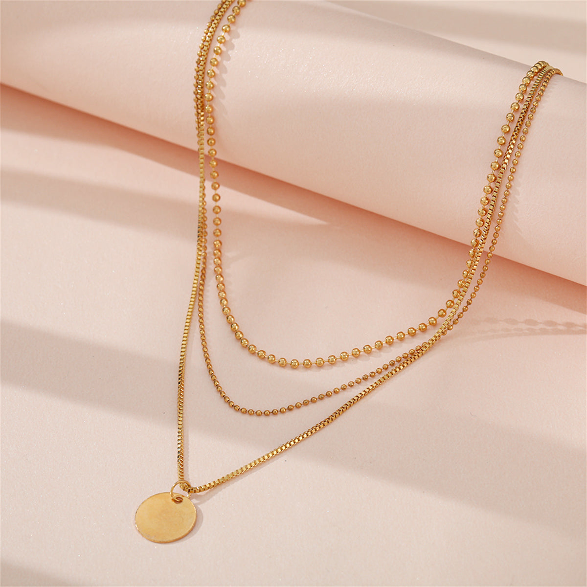 Beautiful 18K gold-plated circle pendant necklace with two chains, offering a trendy three-layer design for effortless elegance.