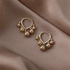 Beautiful 18K gold-plated huggie earrings with playful ball tassels, perfect for making a fashionable statement.