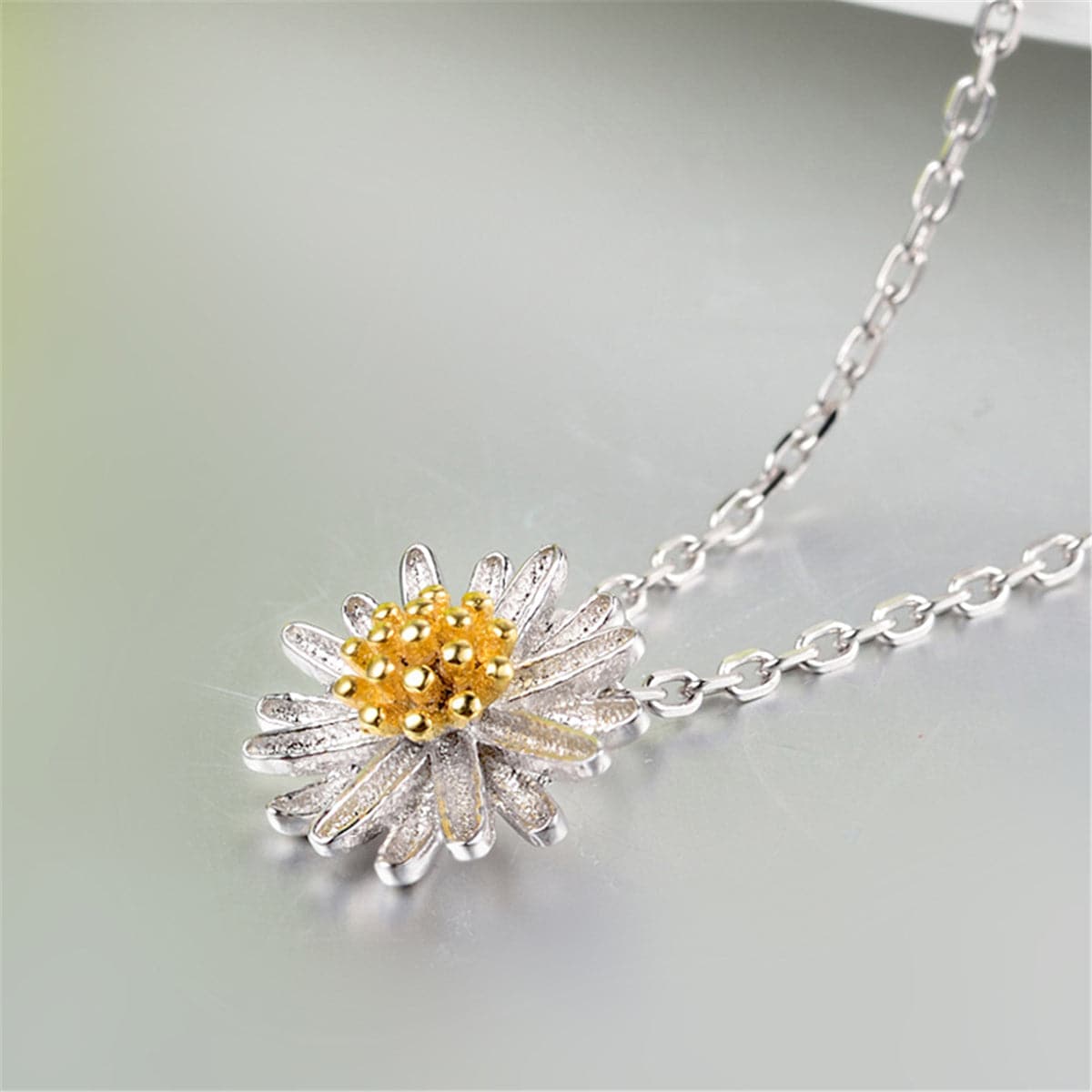 Stunning white and yellow daisy pendant with a gold center, made from 18K gold-plated sterling silver for a perfect gift.