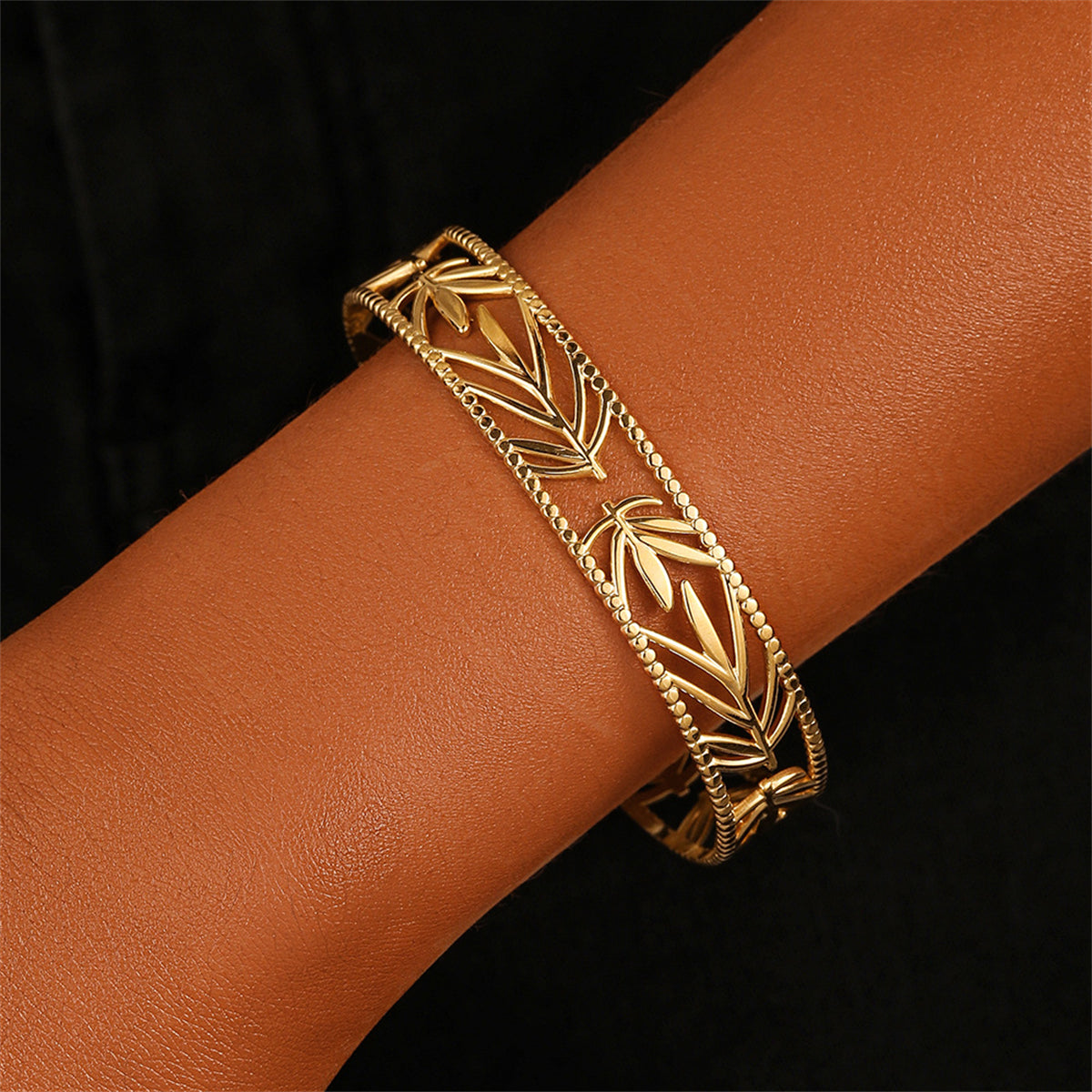 Elegant 18K gold-plated cuff bracelet featuring intricate botanical designs, perfect for adding a touch of luxury to any outfit.