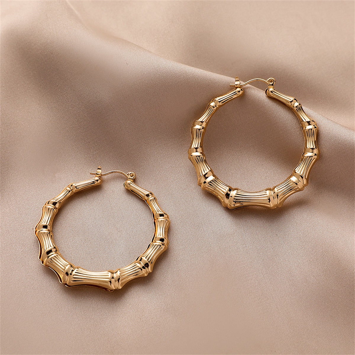 Elegant 18K gold-plated bamboo hoop earrings, showcasing a unique design that adds a touch of sophistication to any outfit.