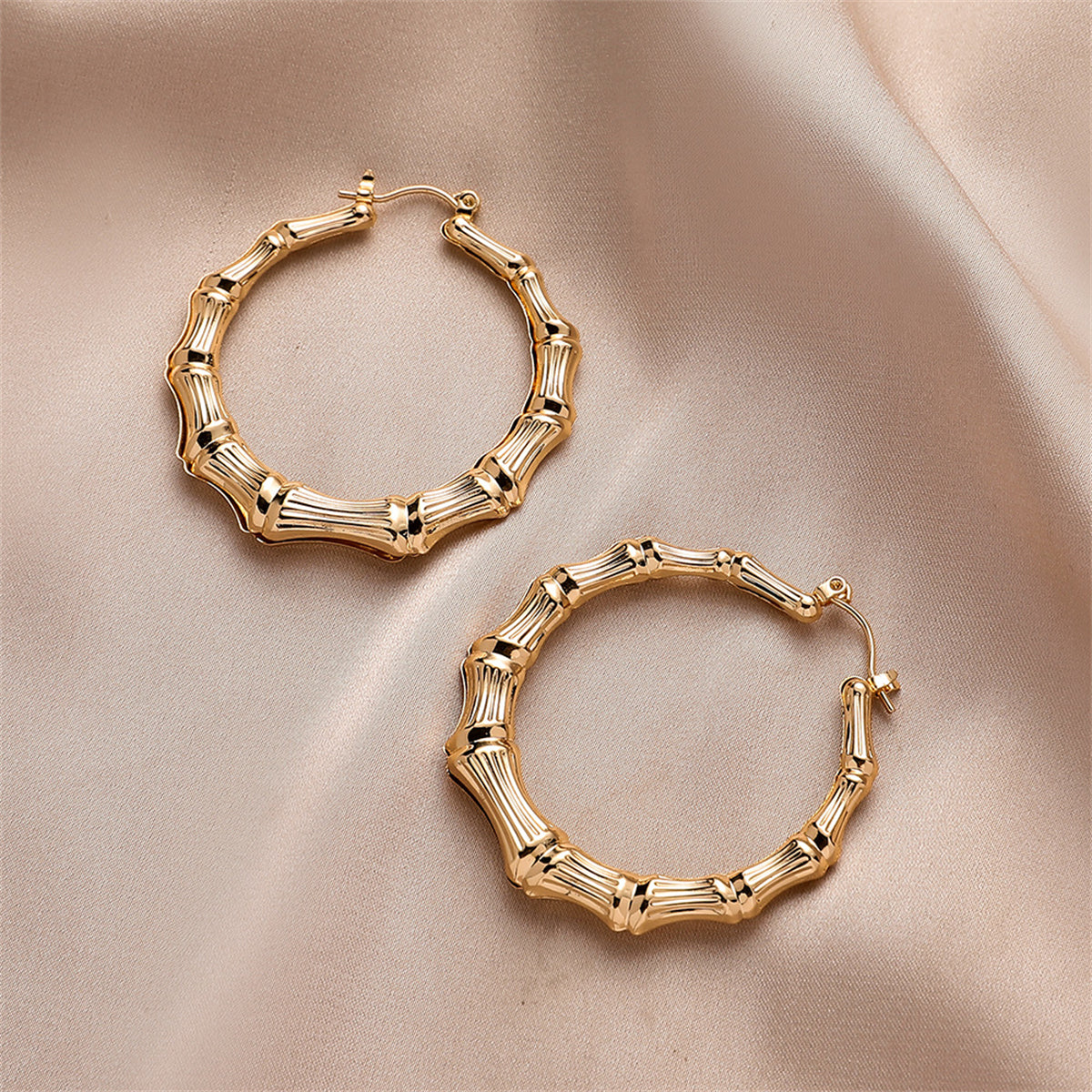 Eye-catching 18K gold-plated bamboo hoop earrings, designed to bring a trendy flair to your jewelry collection.