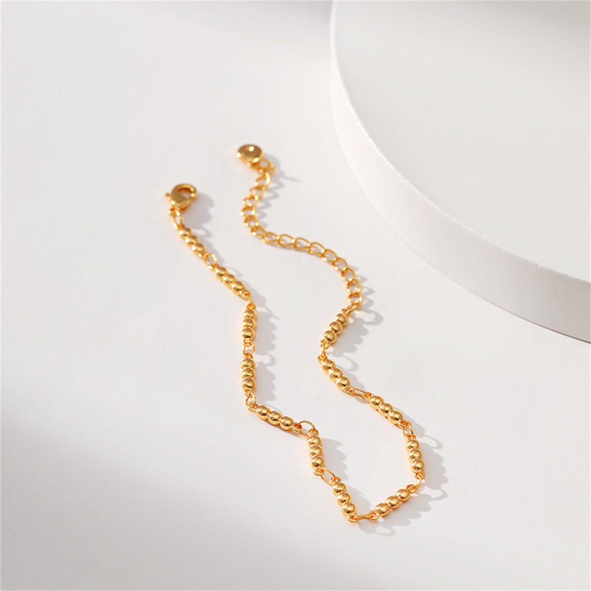 A refined 18K gold-plated bracelet showcasing a gold chain with a small ball at its end, perfect for any occasion.