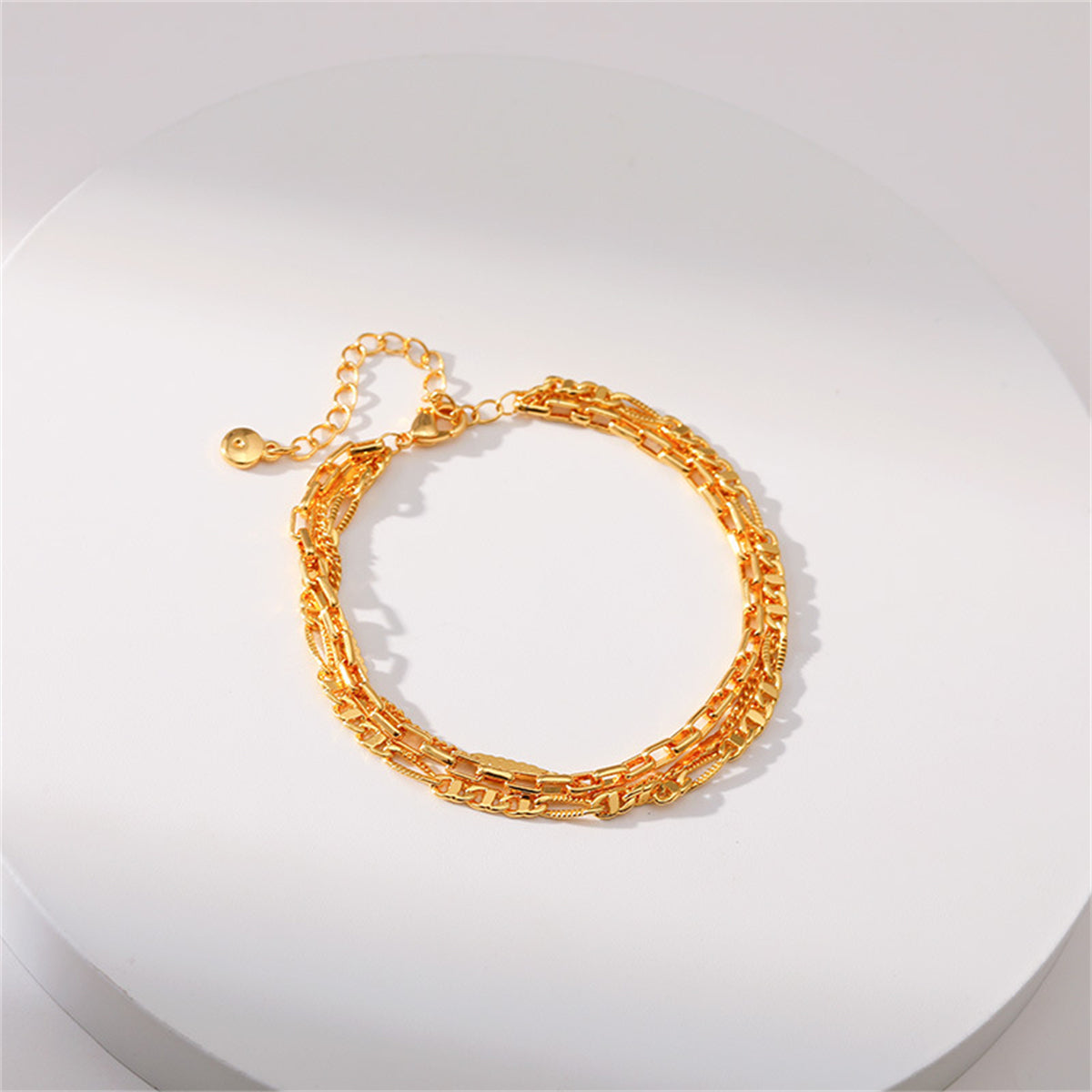 A stylish 18K gold-plated tri-chain bracelet, complete with a clasp and two decorative links.