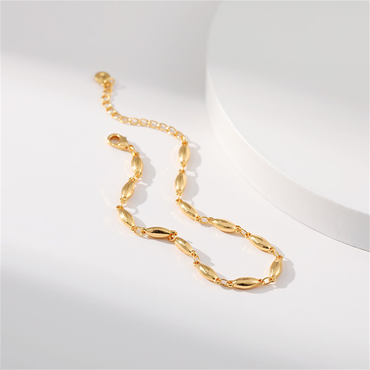 An elegant bracelet made of 18K gold plating, featuring small oval beads in a sophisticated olive chain design.