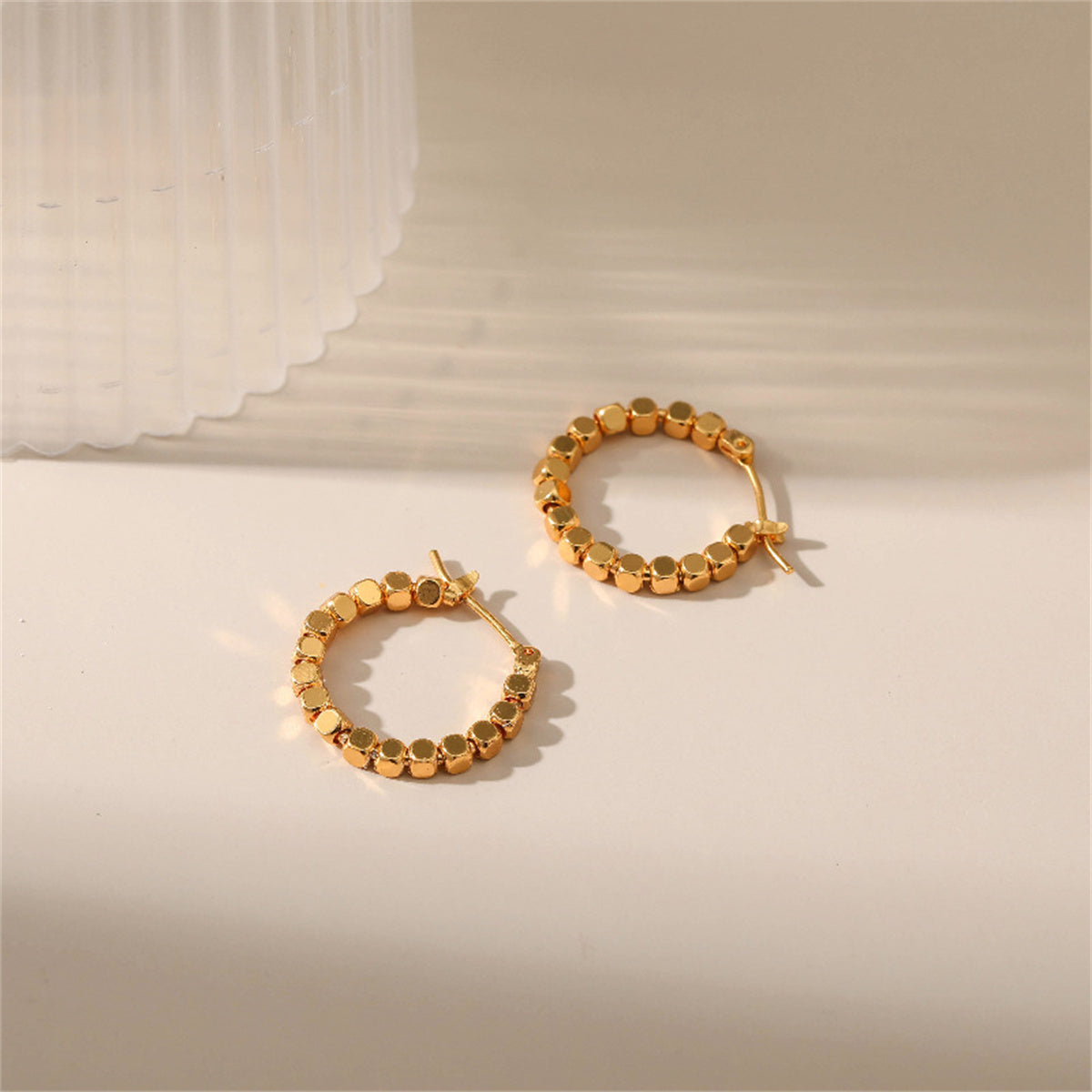 Chic 18k gold round hoop earrings with a unique beaded finish, adding a touch of elegance to your jewelry collection.