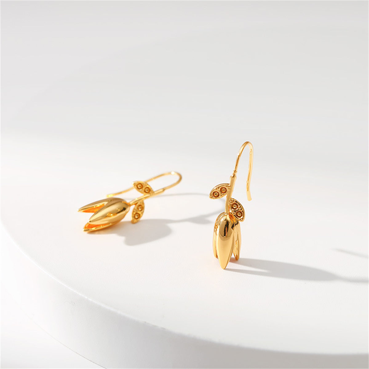 18K gold-plated earrings adorned with delicate leaves and floral motifs, showcasing exquisite craftsmanship.