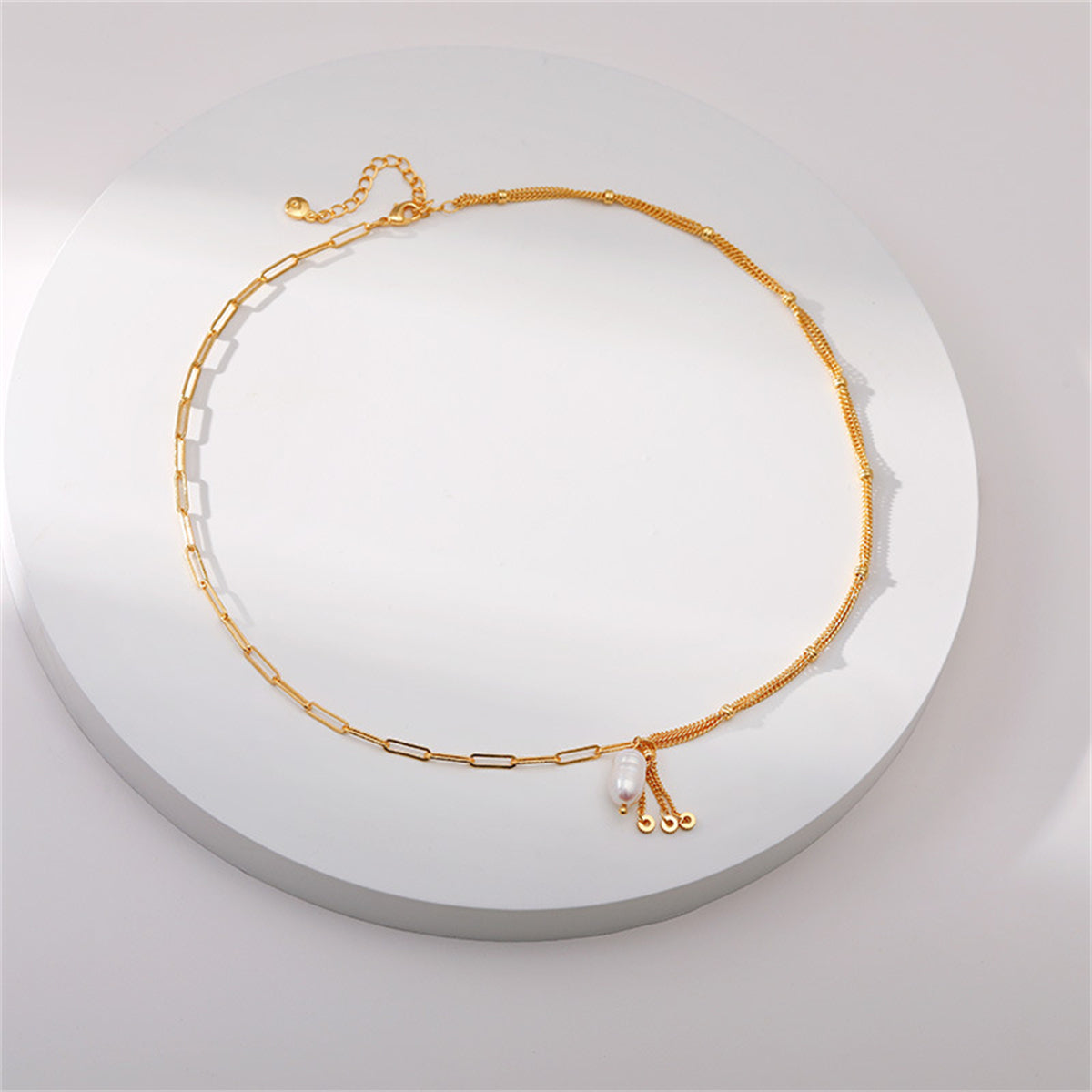A refined multi-chain necklace in 18K gold plating, highlighted by a beautiful pearl pendant.