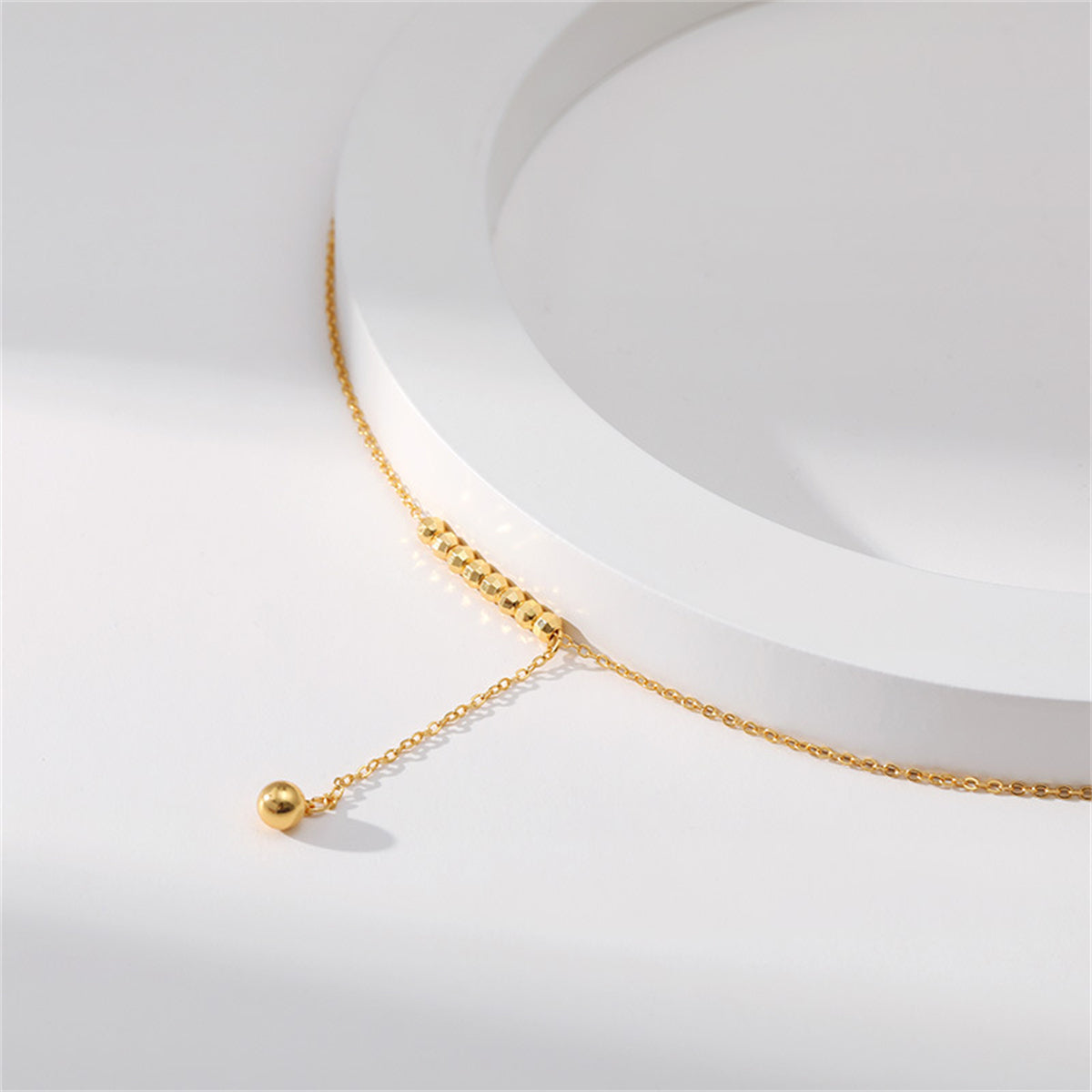 Chic 18K gold-plated bead lariat necklace highlighted by a radiant diamond pendant.