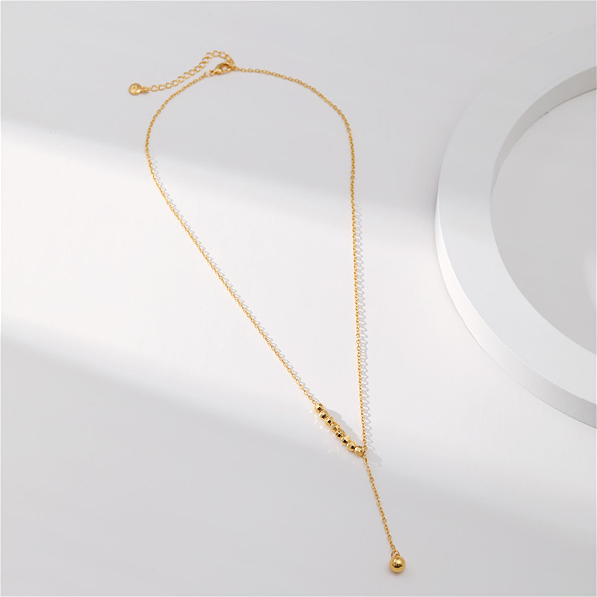 Elegant 18K gold-plated bead lariat necklace adorned with a brilliant diamond pendant.