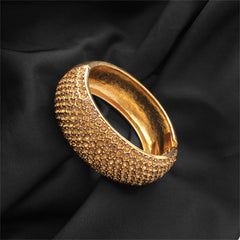  A luxurious gold-tone bangle with a striking cubic zirconia stone, crafted from 18K gold plating for a refined appearance.