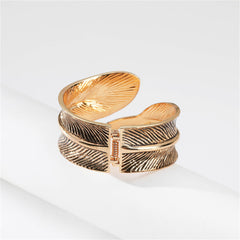 A stylish gold cuff with a feather motif, designed in enamel and 18K gold plating, featuring a unique bypass style.