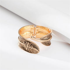 An elegant cuff bracelet in 18K gold plating, showcasing a feather design in enamel, designed as a bypass bangle.