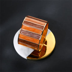 A stylish cuff bracelet with brown and orange stripes, crafted from orange enamel and adorned with 18K gold plating.

