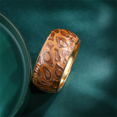 A sophisticated gold and brown bangle adorned with a patterned design, featuring brown enamel and 18K gold plating.