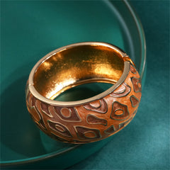 A luxurious gold and brown bangle with a distinctive pattern, composed of brown enamel and 18K gold plating.