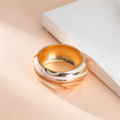 An elegant bracelet in gold and orange, featuring a swirl motif, made from orange enamel and 18K gold plating.