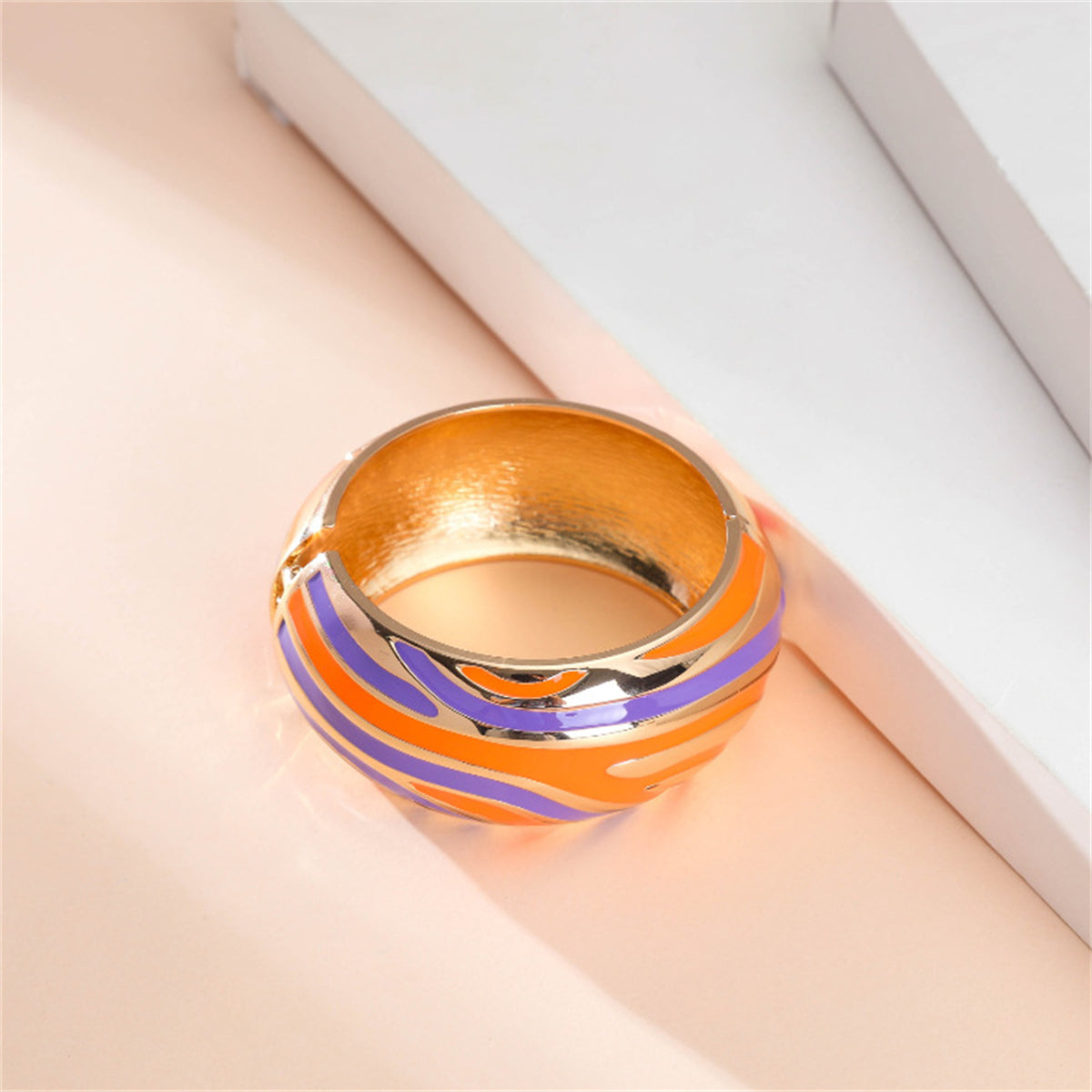 An elegant bracelet showcasing orange and blue stripes with gold accents, complemented by 18K gold-plated stripes for added luxury.