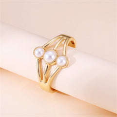 A luxurious gold-plated bangle adorned with three pristine white pearls, showcasing a sophisticated layered bangle style.
