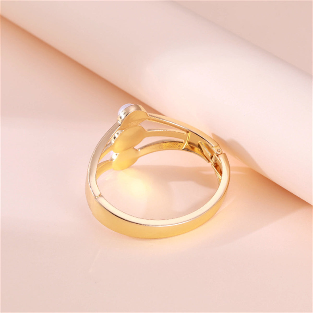 A beautiful gold-plated bangle set with three white pearls, reflecting a contemporary layered bangle design.