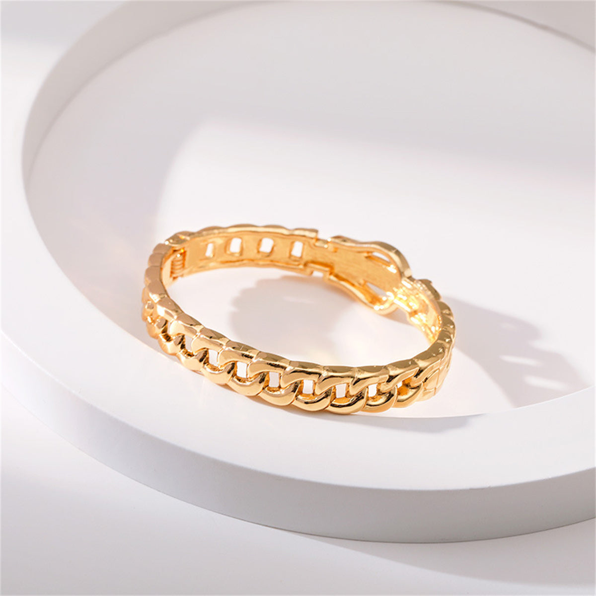 A refined yellow gold bracelet set with diamonds, incorporating a cubic zirconia and an 18K gold-plated belt buckle design.
