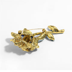 A stunning blue and green crystal flower brooch, embellished with blue cubic zirconia and finished in 18K gold plating.
