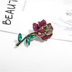 Exquisite pink rose brooch with green leaves and pink crystals, made with 18K gold plating and sparkling cubic zirconia.