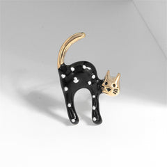 A chic black and white cat pin, designed with black enamel and highlighted by an 18K gold-plated spot.