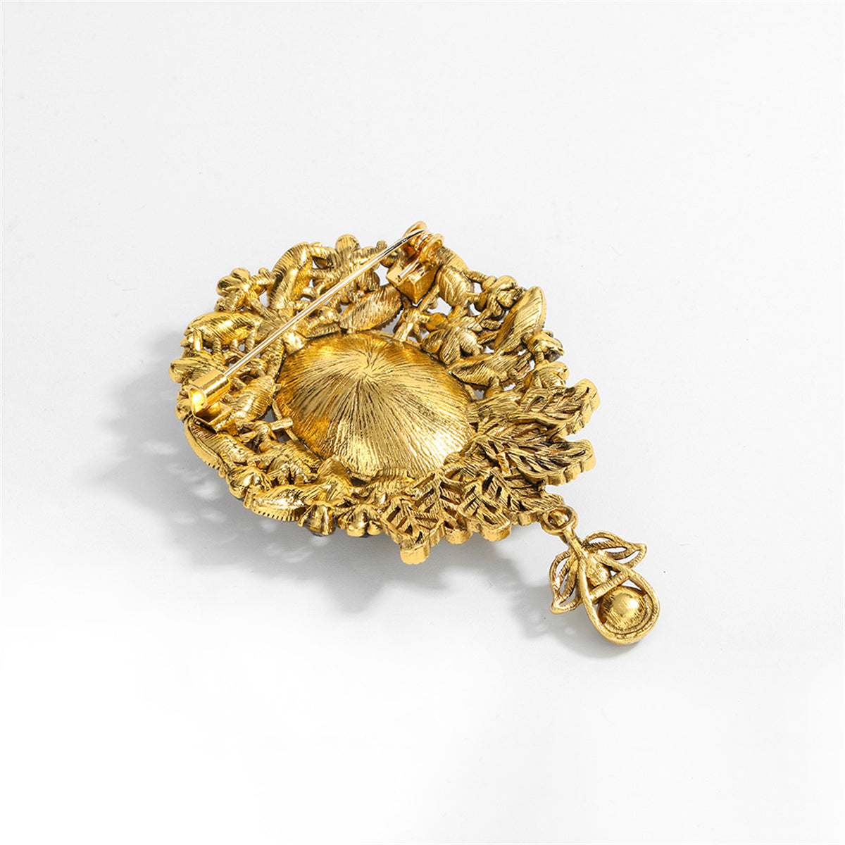 A stunning blue and gold brooch showcasing a large oval stone, crafted with cubic zirconia in a flower drop style.