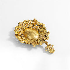 A stunning blue and gold brooch showcasing a large oval stone, crafted with cubic zirconia in a flower drop style.