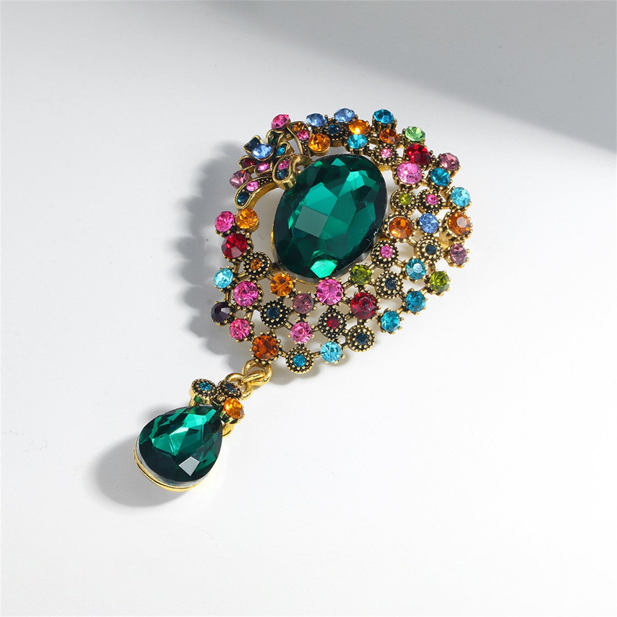A stunning green brooch with multicolored accents, featuring a teardrop design crafted from crystals and cubic zirconia.