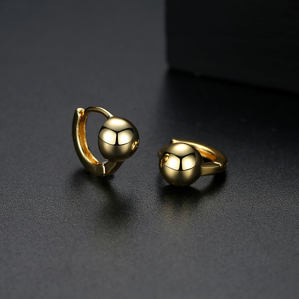 Elegant 18K gold-plated ball huggie earrings, showcasing a stunning gold tone for a chic and sophisticated look.