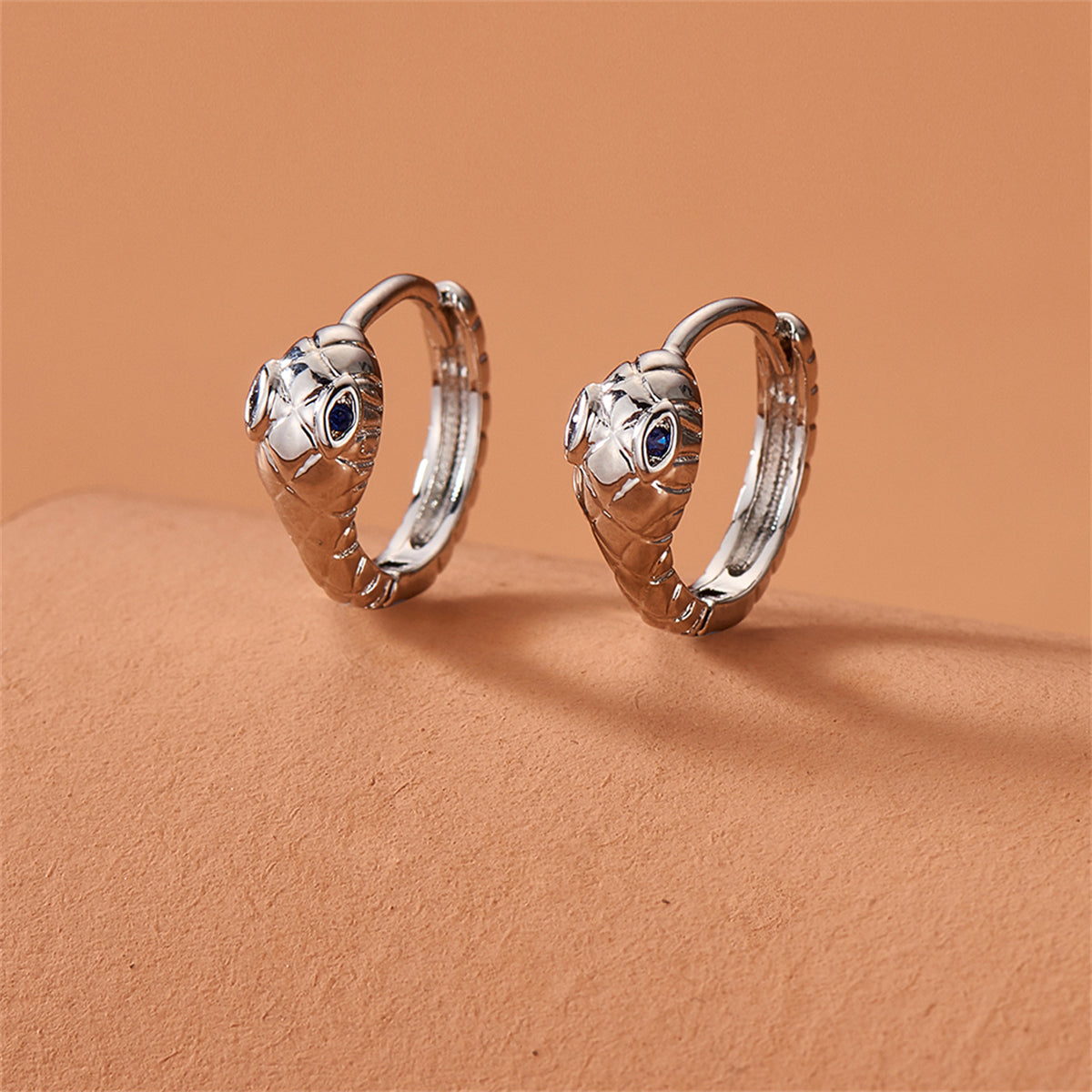 Blue Cubic Zirconia and Silver-Plated Snake Huggie Earrings, silver huggie earrings, dainty minimalist design, front view