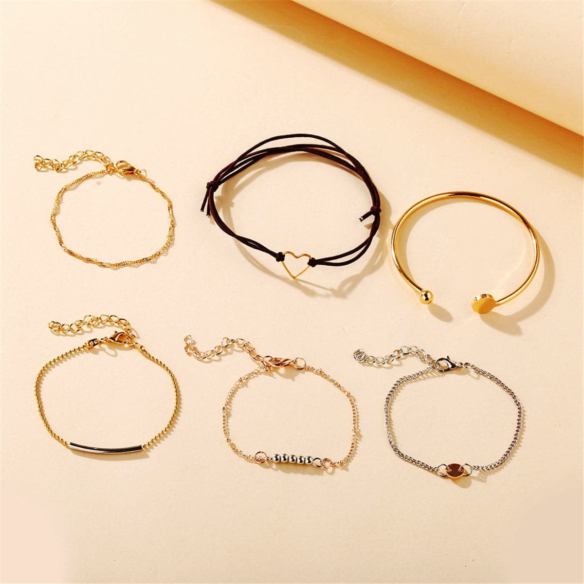 A fashionable set of bracelets featuring a heart charm, beautifully plated in 18K gold and silver for a trendy look.