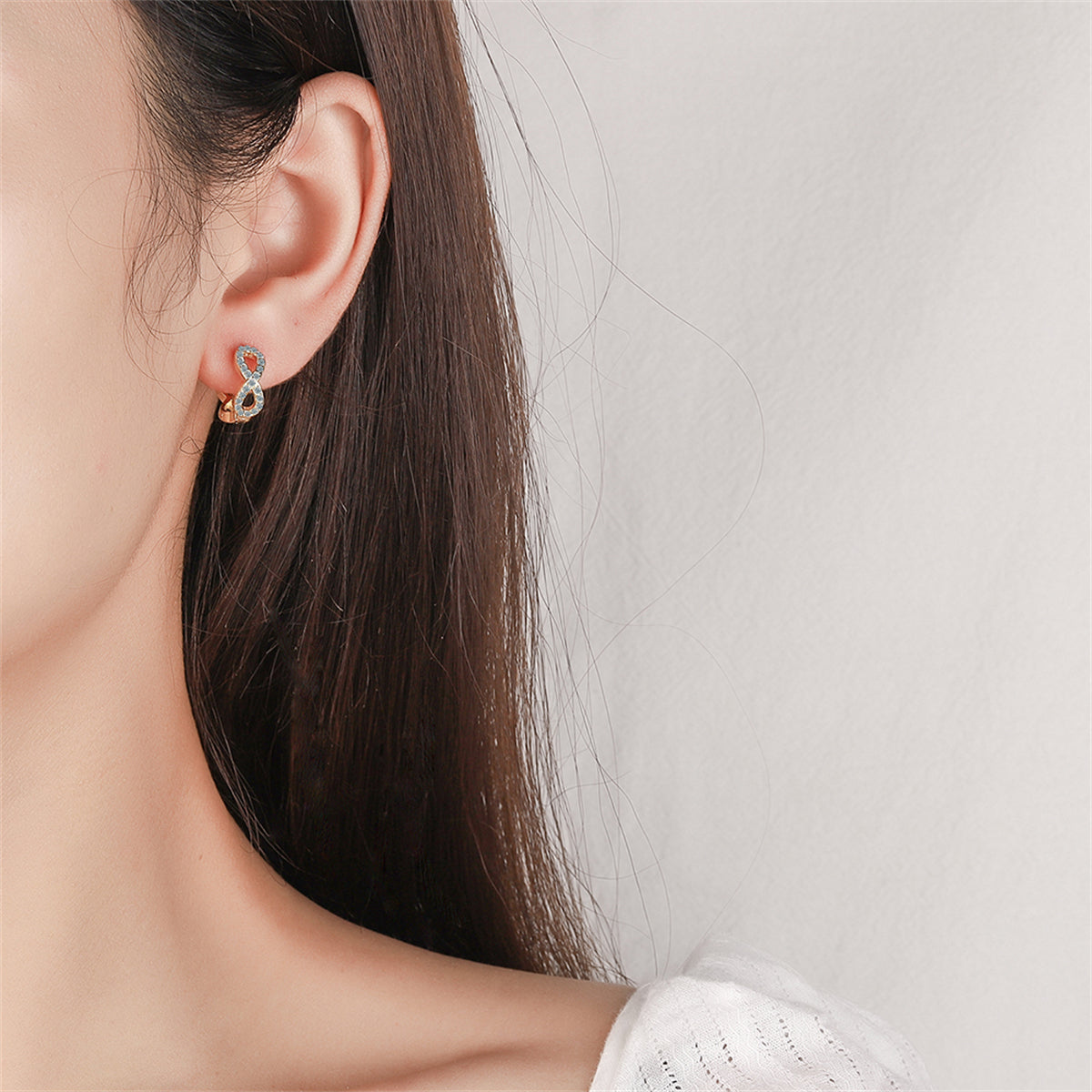 Cubic Zirconia and 18K Gold-Plated Infinity Huggie Earrings, gold huggie earrings, dainty minimalist design, lifestyle look