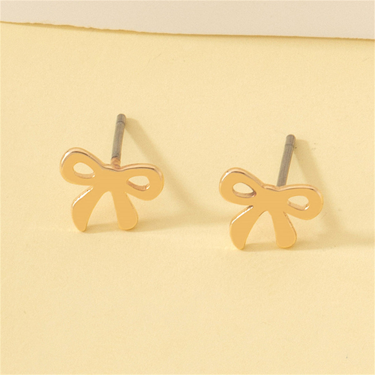 Elegant 18K gold-plated bow stud earrings, perfect for adding a touch of sophistication to any outfit.