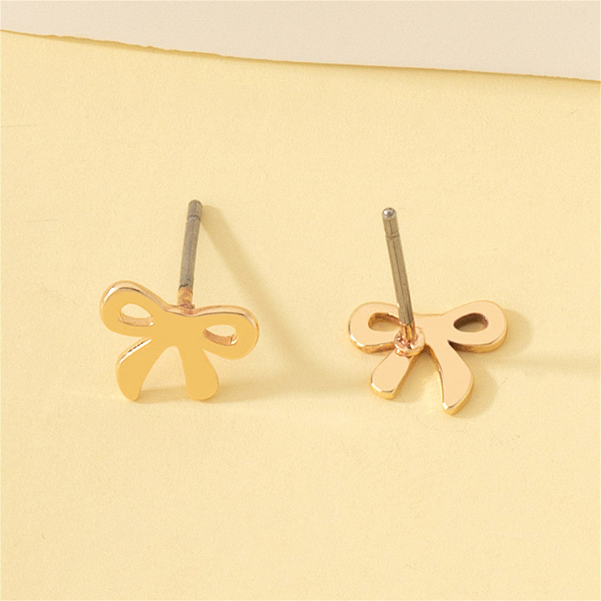 Charming 18K gold-plated bow stud earrings, the perfect finishing touch for any ensemble, radiating elegance.