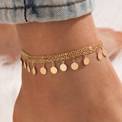Elegant 18K gold-plated anklet featuring a delicate chain adorned with small disc charms for a stylish touch.
