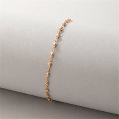 Chic 18K gold-plated beaded chain anklet showcased on a white surface, reflecting its stylish and luxurious appeal.