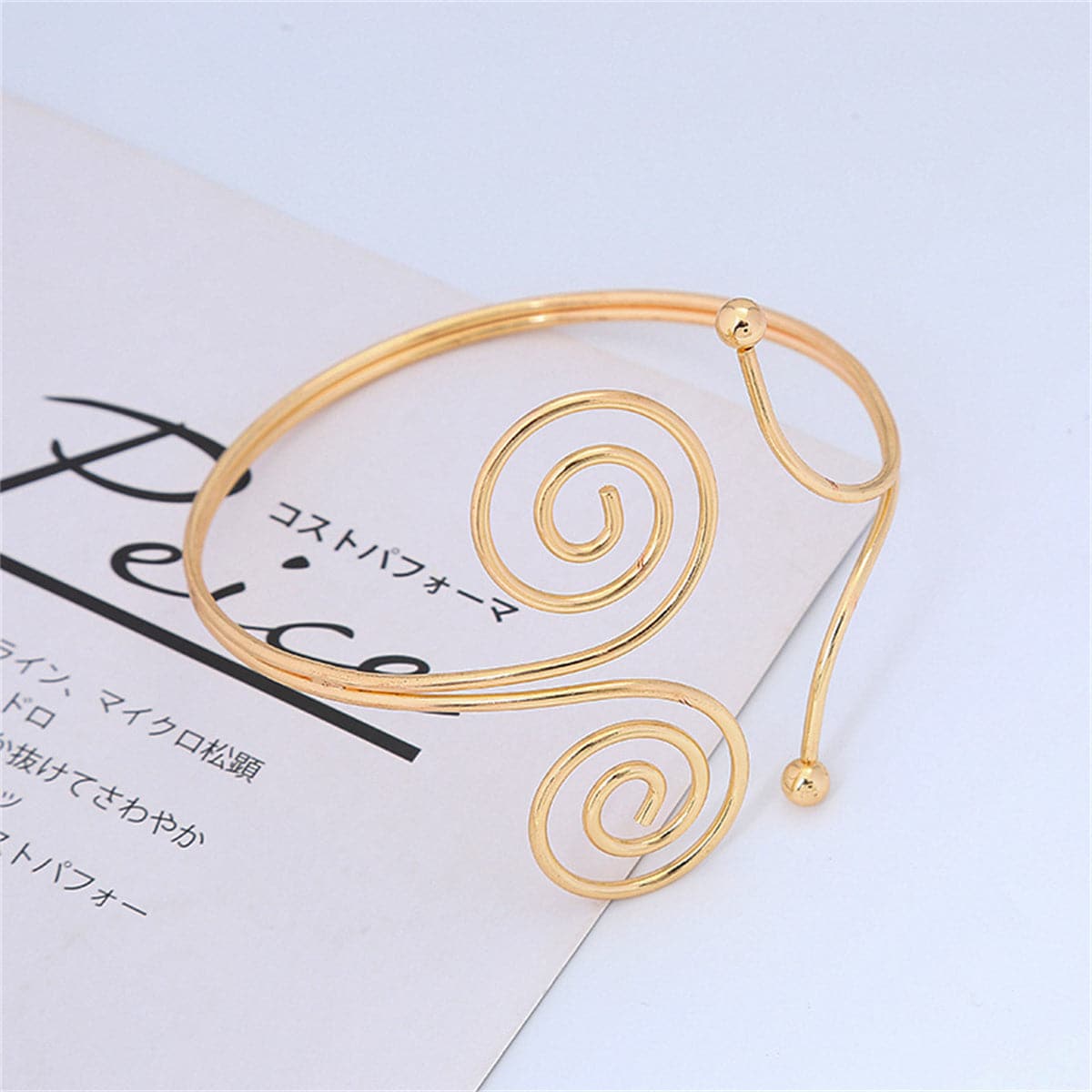 18K gold-plated arm cuff with a unique spiral design, perfect for adding a touch of elegance to any outfit.