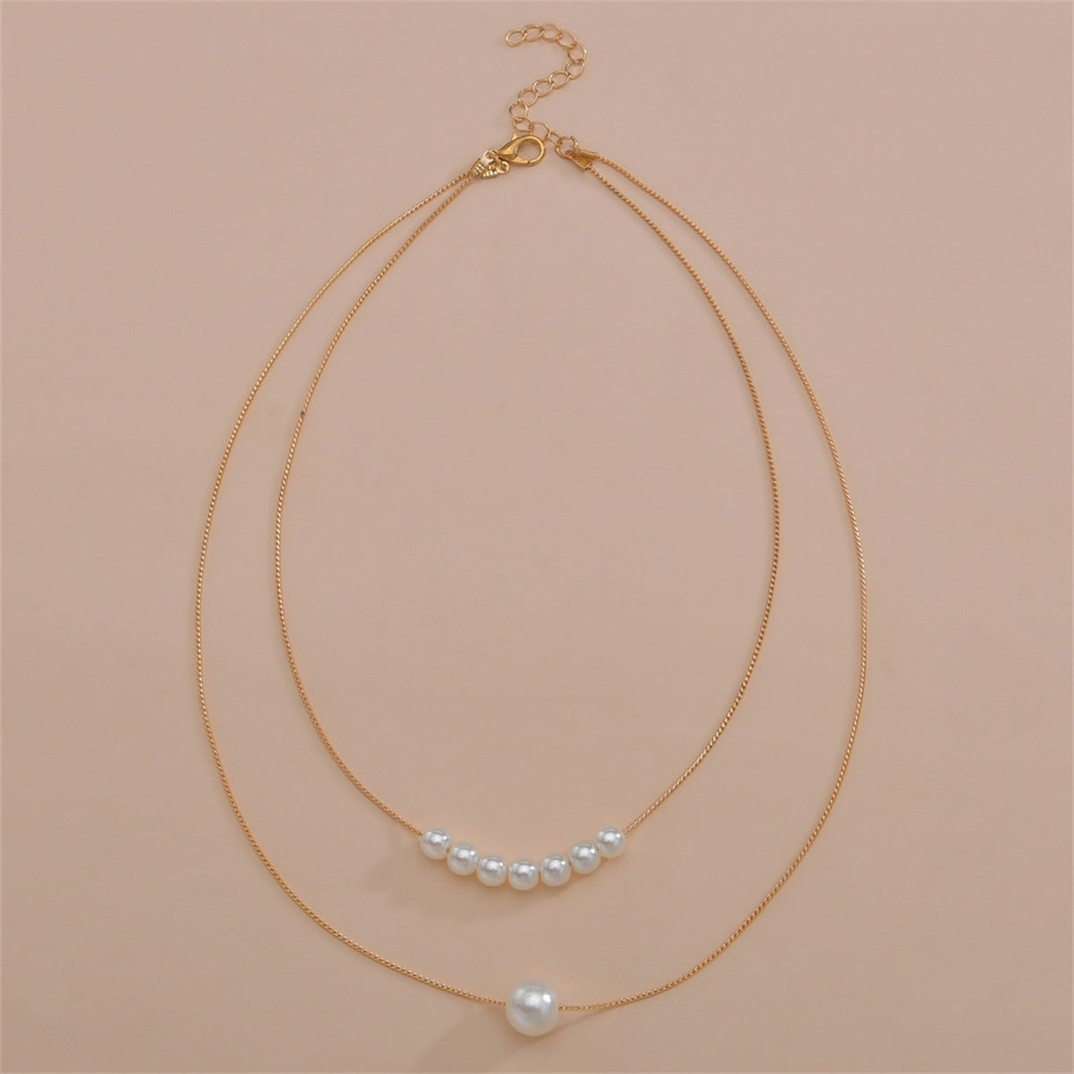 A refined necklace with two layers of pearls on a gold chain, emphasizing the luxurious 18K gold-plated design.
