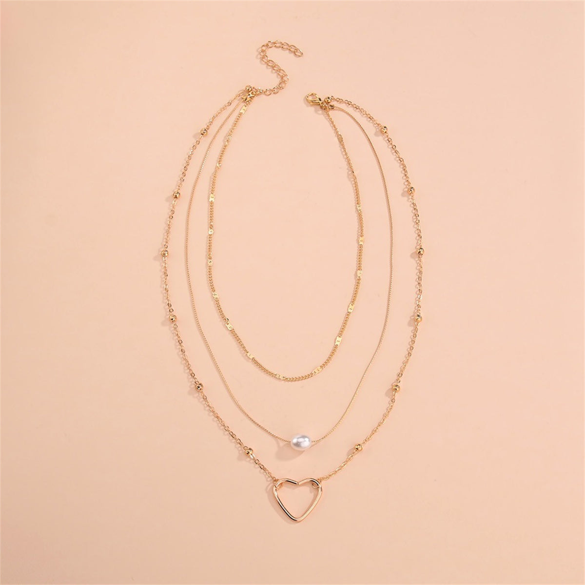 A beautiful layered necklace with an 18K gold-plated heart pendant and a pearl, perfect for elegant occasions.