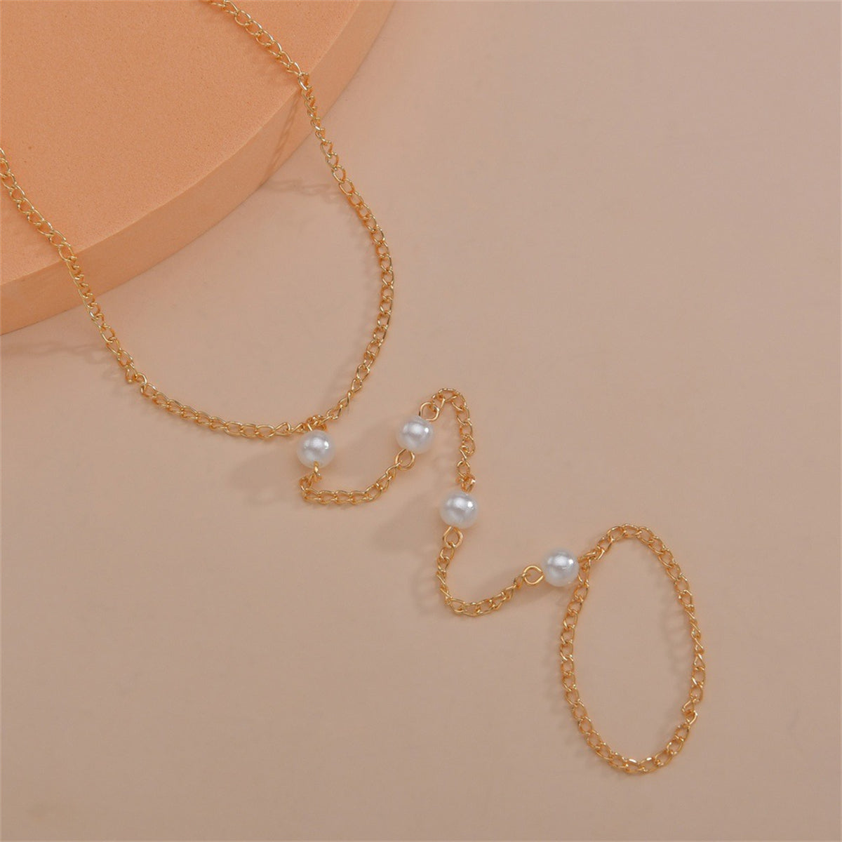 A stylish gold chain anklet embellished with pearls, combining classic beauty with modern design.