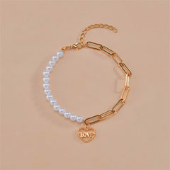 White pearl bracelet with a gold heart charm, showcasing a blend of classic elegance and heartfelt sentiment.