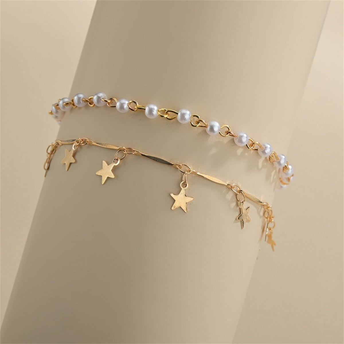 A luxurious anklet set with a gold chain, embellished with stars and pearls, featuring a chic tassel design.