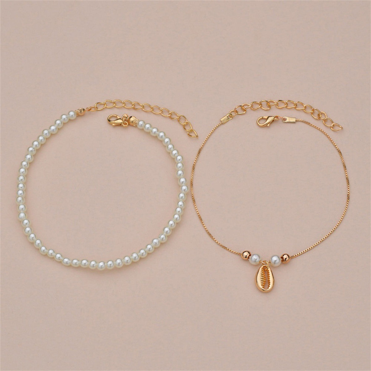 Two beautiful anklets combining pearls and gold chains, featuring a pearl and 18K gold-plated shell charm design.