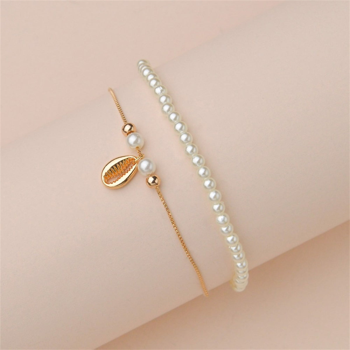 Two exquisite anklets with pearls and gold chains, designed as a pearl and 18K gold-plated shell charm anklet set.