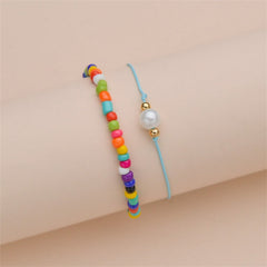 Two anklets with rainbow beads and a blue cord, representing the Red Multicolor Howlite Stretch Anklet Set.